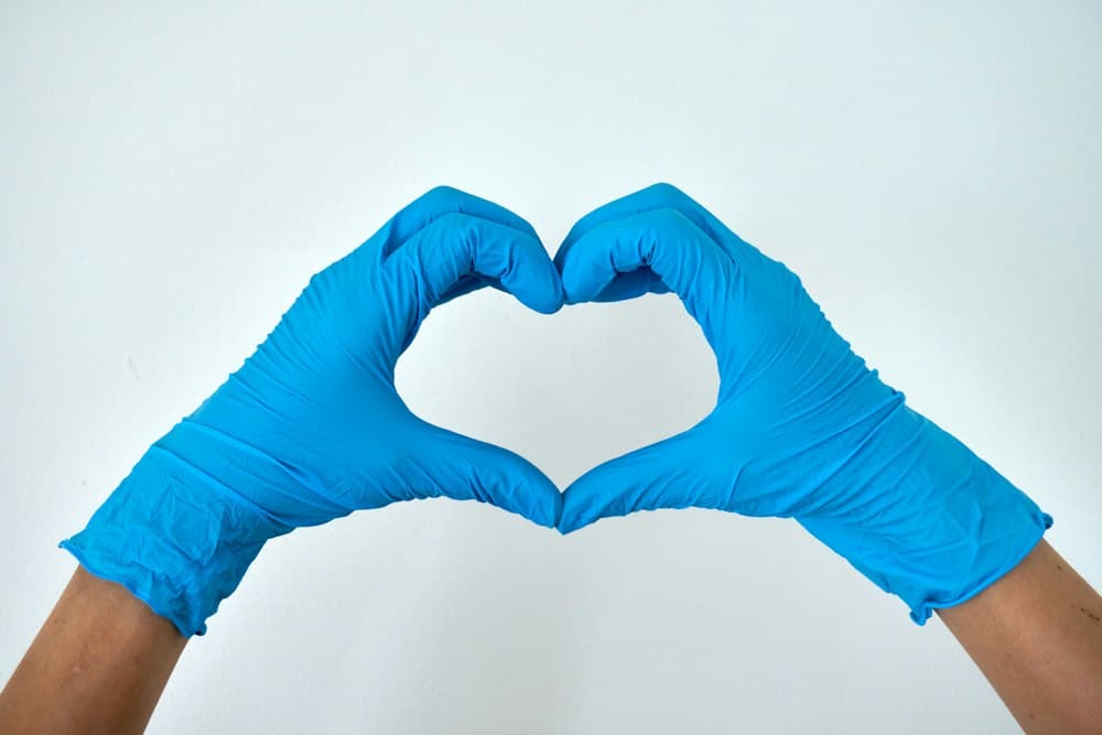Two gloved hands making a heart shape