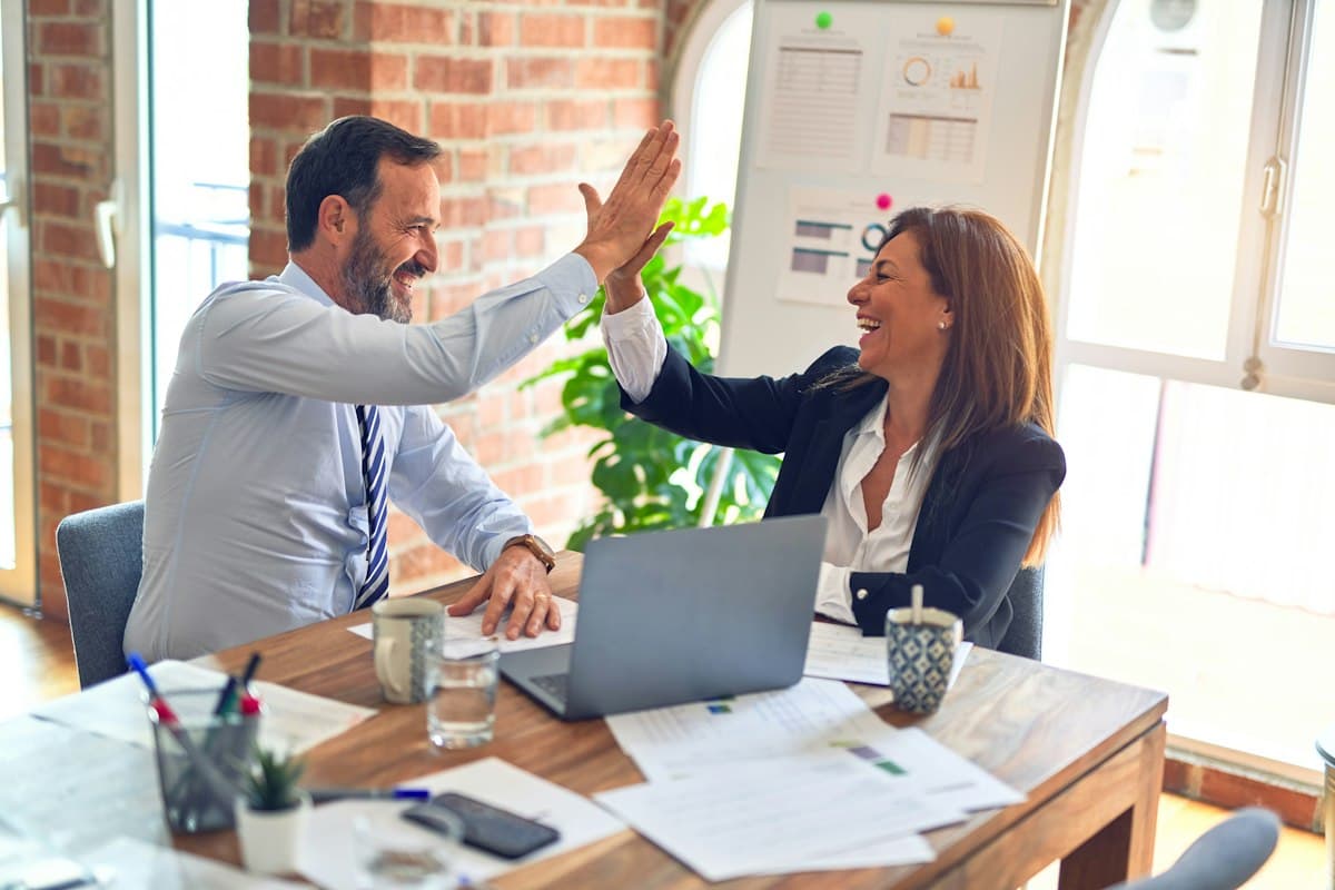 Two business owners celebrating at a desk